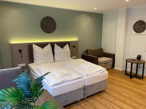 ein Schlafzimmer mit einem großen weißen Bett und einer Couch in der Unterkunft Living Inn in Rheda-Wiedenbrück