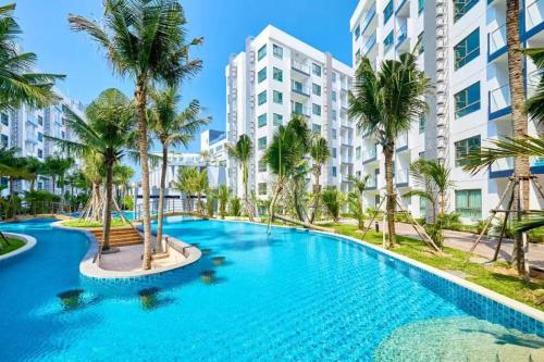 Una piscina con palmeras frente a un edificio. en Arcadia Beach Continental, en Pattaya South