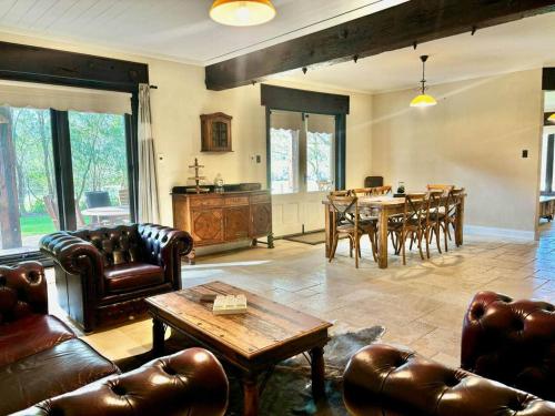 een woonkamer met leren meubels en een tafel bij Little River Valley in Denmark