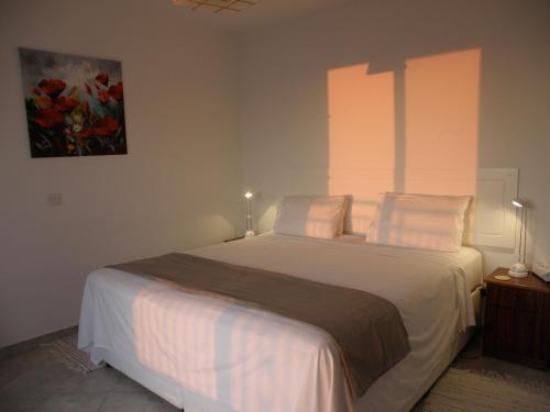 um quarto com uma grande cama branca e 2 almofadas em 20 Kissonerga Sunset em Kissonerga