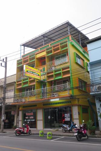 two motorcycles parked in front of a building at Nadpob Mansion in Surat Thani