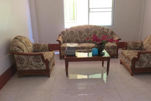 a living room with two chairs and a coffee table at Nadpob Mansion in Surat Thani