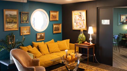 Hôtel Kyriad Brive Ouest في بريف لا غايلارد: غرفة معيشة مع أريكة صفراء وطاولة