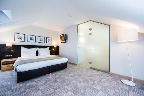 a bedroom with a large bed and a glass shower at Hotel Sokół Wellness & SPA in Łańcut
