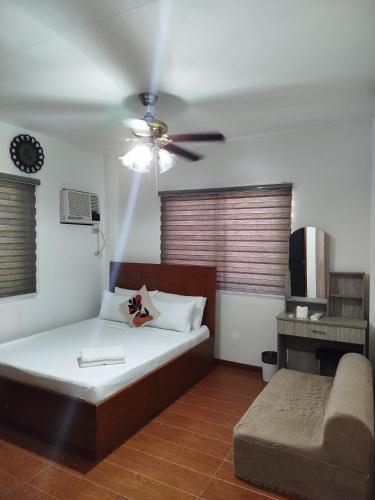 a bedroom with a bed and a ceiling fan at Matthew's Tranquil Homestay in General Luna