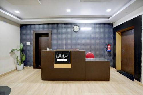 Collection O KIIT Square Bhubaneswar Formerly Nilay Classic في Bārang: مكتب به مكتب استقبال وساعة معلقة على الحائط