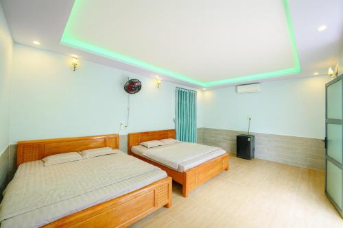 ein Schlafzimmer mit zwei Betten und einem großen Fenster in der Unterkunft ML Homestay in Bình Châu