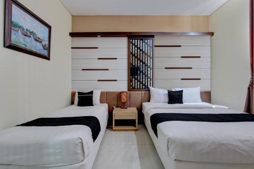 two beds sitting next to each other in a room at Collection O near Stadion Manahan formerly Graha Laweyan Solo in Bonorejo