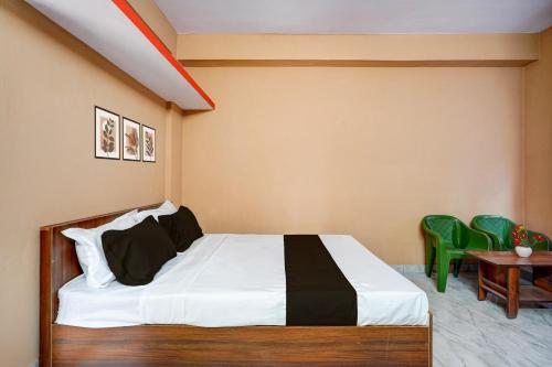 Un dormitorio con una cama y una mesa y sillas. en Hotel O Bidadi Railway Junction Bangalore Formerly Ejalla, en Bidadi