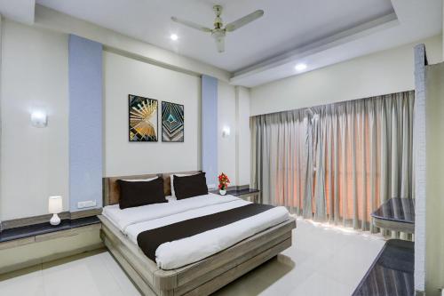 a bedroom with a large bed and a window at Townhouse Kakinada Nagamalli Thota Junction in Kākināda