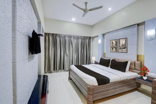 a bedroom with a large bed and a window at Townhouse Kakinada Nagamalli Thota Junction in Kākināda
