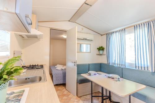 une cuisine avec un évier et une table dans une pièce dans l'établissement Camping Village Costa Est, à Riotorto