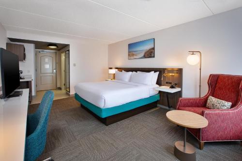 Hilton Garden Inn Chesapeake Greenbrier في تشيسابيك: غرفة فندق مع سرير وكرسي