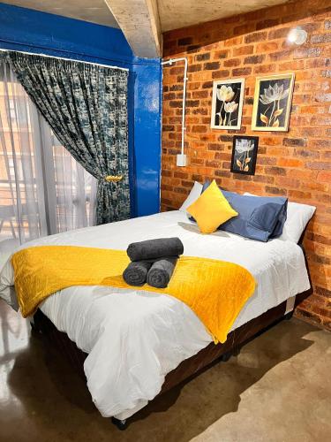 a bedroom with a large bed with yellow and blue pillows at Craftsmanship 340 IMD in Johannesburg