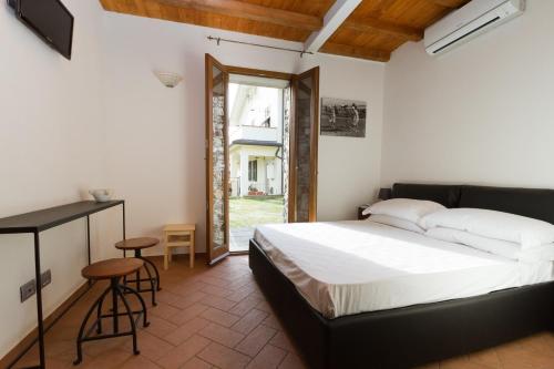 a bedroom with a bed and a table and a window at Il Casale Del Giglio in Santo Stefano di Magra