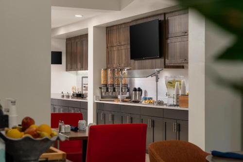 eine Küche mit roten Stühlen und einem Tisch mit einer Schale Obst in der Unterkunft Hilton Garden Inn Rock Hill in Rock Hill