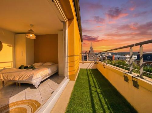 una camera da letto con un letto su un balcone con un tramonto di Le Sky - Penthouse de Standing Hyper-Centre Orsay Paris Saclay a Orsay
