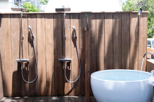 a bathroom with a bath tub and a wooden fence at Beach Front Seretis in Shimoda