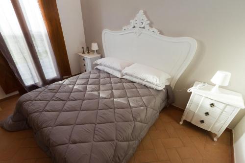 a bedroom with a large bed with a white headboard at Il Casale Del Giglio in Santo Stefano di Magra