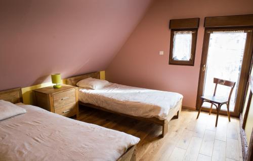 une chambre avec deux lits et une chaise et une fenêtre dans l'établissement Maison A Colombage De 1602, à Wintzenheim