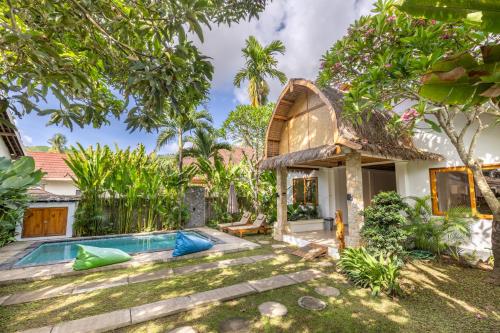 an exterior view of a house with a swimming pool at Villa Trembesi - New Spacious Luxury 2BR Private Villa - Free Gym Access - 60Mbps WiFi in Kuta Lombok