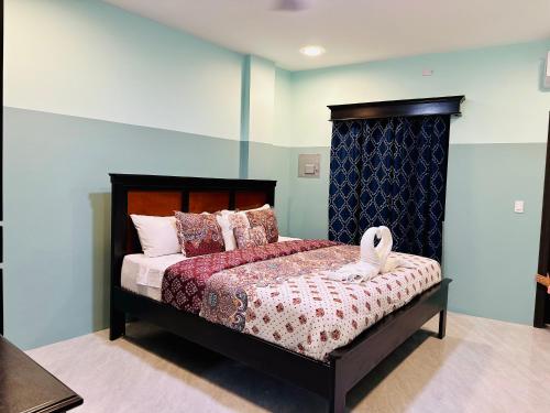 a bedroom with a bed with a wooden headboard at Hotel Sea Queen Suite & Golf Cart Rental in San Pedro