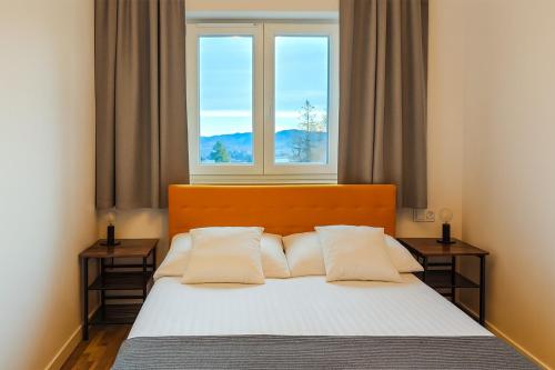 a bedroom with a bed with a window at Apartament Widokowy Karpacz z garażem i widokiem na góry, blisko szlaki i centrum in Karpacz