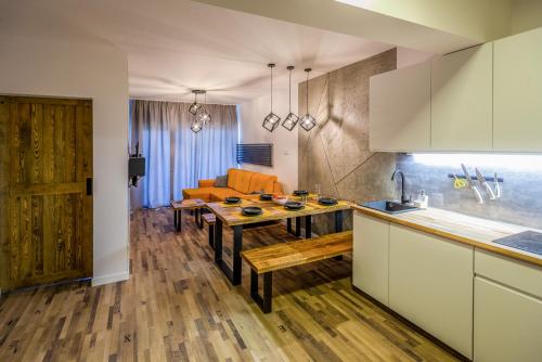a kitchen and living room with a wooden table at Apartament Widokowy Karpacz z garażem i widokiem na góry, blisko szlaki i centrum in Karpacz