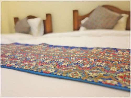 a blanket on top of a bed with two beds at Baan Bussaba Hotel in Trang