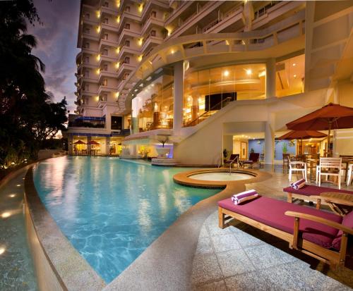 a swimming pool in a hotel with a building at Dorsett Grand Labuan in Labuan