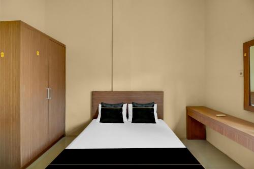 a small bedroom with a bed and a cabinet at Hotel O near Trans Studio Theme Park formerly Cyloam Residence in Legian