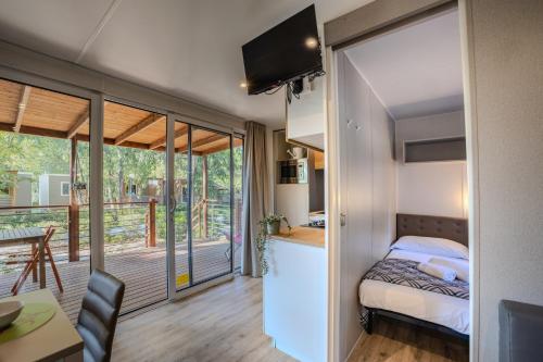 une petite chambre avec un lit et un balcon dans l'établissement Camping Village Costa Est, à Riotorto