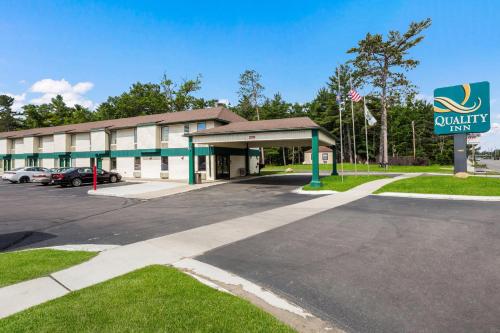 a building with a car parked in a parking lot at Quality Inn Traverse City in Traverse City