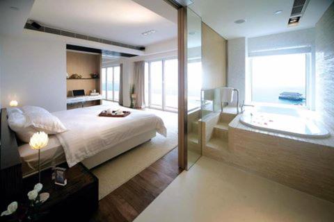 um quarto com uma cama e uma casa de banho com uma banheira em Stanley Oriental Hotel em Hong Kong