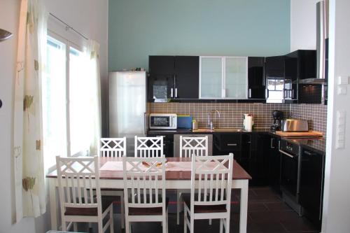 una cucina con tavolo e sedie e una cucina con armadi neri di Villa Ilves A a Syöte