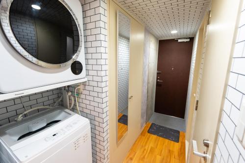 a small bathroom with a washing machine and a mirror at Villa Boushu KURAMAE in Tokyo