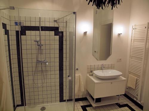 a bathroom with a sink and a shower and a mirror at Regis Residence in Bochnia