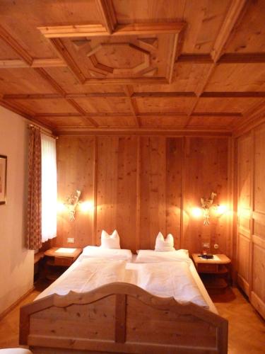 Un dormitorio con una cama grande con techo de madera. en Chalet Ciasa Alexander, en San Cassiano
