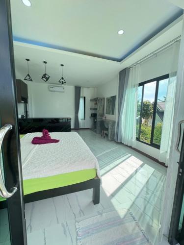 een slaapkamer met een bed en een groot raam bij Seaview phuwamin in Phra Ae beach