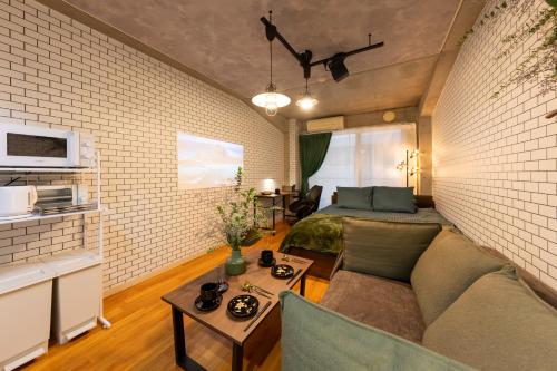 a living room with a couch and a bed in a room at Villa Boushu KURAMAE in Tokyo