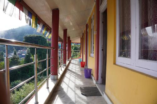 Cholo Ghure Ashi-Sillery Gaon Homestay في Pedong: مبنى مع شرفة مطلة على الجبل