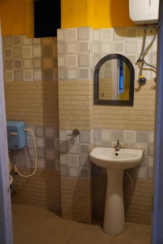 Cholo Ghure Ashi-Sillery Gaon Homestay في Pedong: حمام مزود بحوض ومِرآة