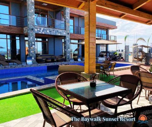 a patio with a table and chairs next to a pool at The Baywalk Sunset Resort in Agoo