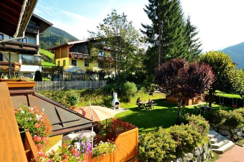 a view of a garden with people sitting on a bench at Pension Mozart in Wagrain