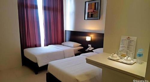 Una cama o camas en una habitación de Manhattan Suites Inn