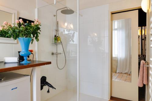 baño con ducha y jarrón de flores en Suite dans une échoppe, en Bègles