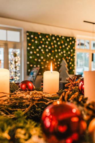ein mit Kerzen und Weihnachtsdekorationen geschmückter Tisch in der Unterkunft Hotel Villa Belvedere in Binz