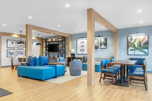 a living room with blue furniture and a dining room at Everhome Suites Bowling Green by Choice Hotels in Bowling Green