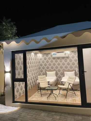 una stanza con due sedie, un tavolo e delle sedie di Neem camp a Nizwa