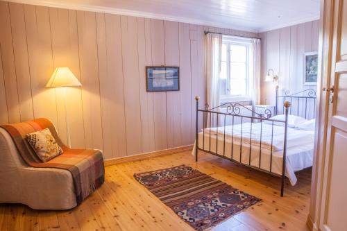 a bedroom with a bed and a chair at Kleivstua Hotel near Krokskogen in Sundvollen